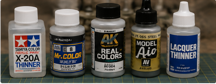 Selection of model paints and thinners arranged on a workbench